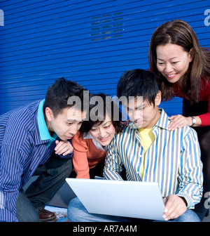 Group of young businesspeople looking at laptop Stock Photo