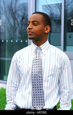 Portrait of a young handsome businessman next to a corporate building Stock Photo