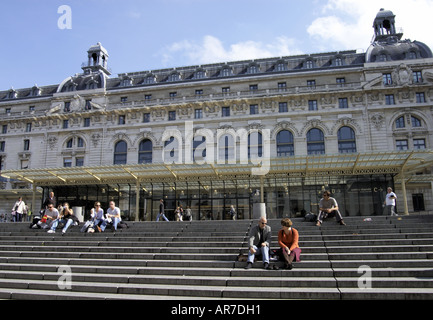 tourists sitting on steps outside the front entrance of Musee d Orsay in Paris Stock Photo