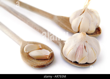 Bulbs and cloves of garlic on wooden spoons isolated on white background Stock Photo