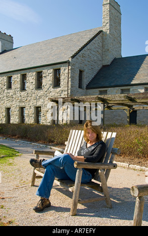 Woman sitting on bench overlooking Whistling Straits Golf Course, Kohler, Wisconsin, USA Stock Photo