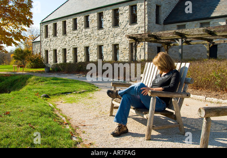 Woman sitting on bench overlooking Whistling Straits Golf Course, Kohler, Wisconsin, USA Stock Photo