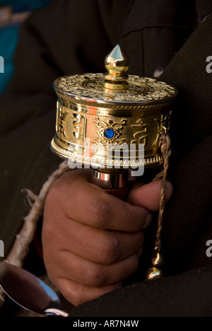 Close up of a Mani Prayer wheel held by an elderly woman pilgrim entering the Potala Palace on Tibetan New year Stock Photo