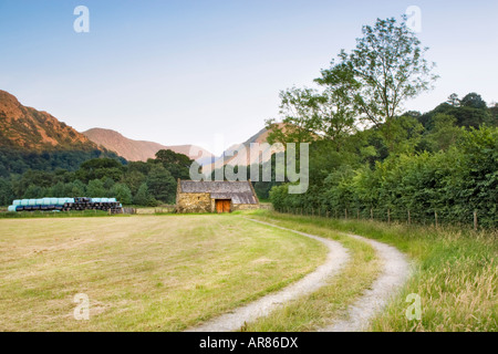 A barn and covered hay bails in farmland in Bridgend, Cumbria in the Lake District National Park. Stock Photo