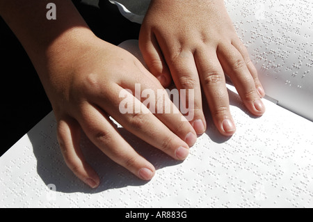 Blind person reading Bible written in Braille Stock Photo