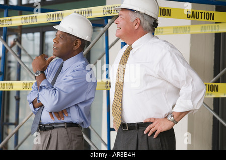 Side profile of two engineers standing in a construction site Stock Photo