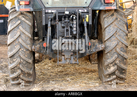 a view of the rear of an agricultural tractor showing wheels tyres and power take of pto and lifting arms Stock Photo