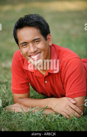 Young man portrait close-up lying on grass outdoors, MR-9-7-07 Stock Photo