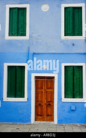 A blue house with green shutters is typical of the brightly painted dwellings in Burano, Italy, an island near Venice. Stock Photo