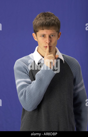 A man with his finger to his mouth saying be quiet or hush Stock Photo