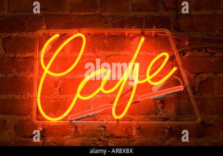 a neon sign on a brick wall outside of a cafe Stock Photo
