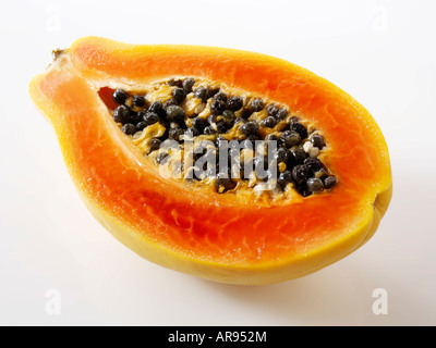 papaya tropical fruit cut in half against a white background as a cut out Stock Photo