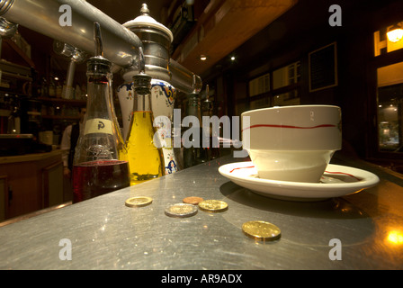 Cup of coffee and loose change on a typical zinc bar counter in Paris Stock Photo