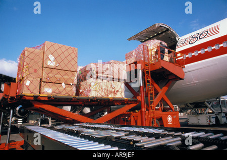 Boeing 747 jumbo jet loading cargo freight containers pallets against a cloudy sky men workers personell Stock Photo