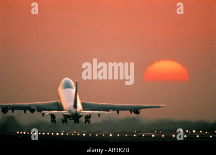 airliner Boeing 747 jumbo jet airliner taking off at sunset sunrise dusk showing jet thrust exhaust Stock Photo