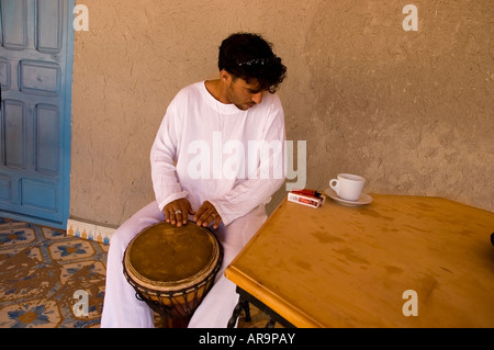 Berber man with white tunic play African drum after the breakfast in the morning Stock Photo