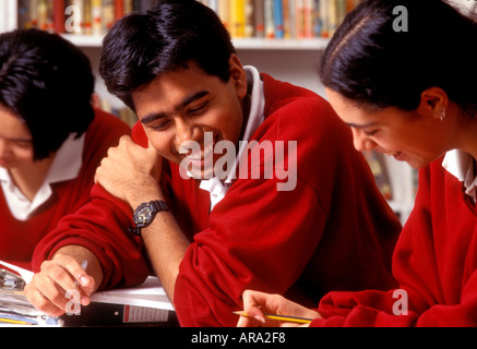 Three senior teenage students working on a project  together in classroom Stock Photo