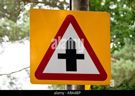 Caution crossroads junction ahead road sign Stock Photo