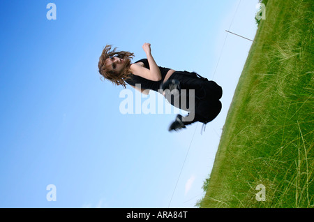 Happy woman jumping against blue sky Stock Photo