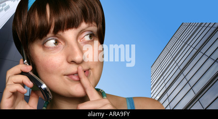 Teenage girl talking with cell phone. Buildings in background Stock Photo