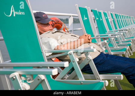 A passenger sleeping on a deck chair on the sun deck of the cruiser 'MS Amadeus Royal' Stock Photo