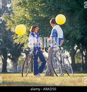 young couple on bikes relaxing in park Stock Photo