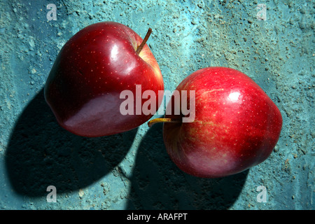 Two red apples on a blue rustic background. Stock Photo