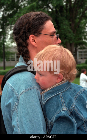 Native American Indian dad holding son age 30 and 2 on Memorial Day . St Paul Minnesota MN USA Stock Photo