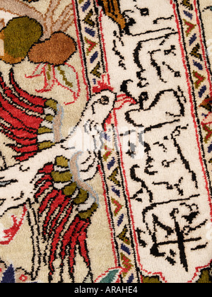 Iranian Persian carpet detail with exotic bird and arabic text words calligraphy Stock Photo