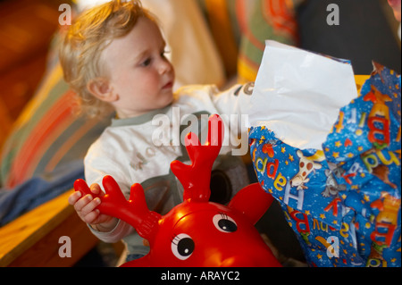 baby sitting on red inflatable elk Stock Photo