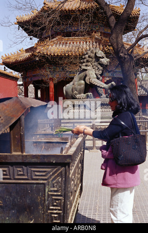 Woman Lighting Incense at The Lamma Temple, Beijing, China Stock Photo