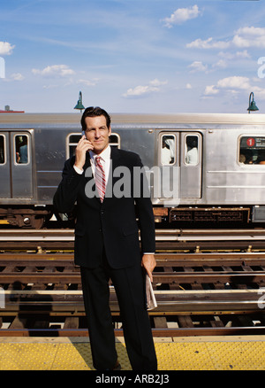 Businessman on Subway Platform, Talking on Cellular Phone Stock Photo