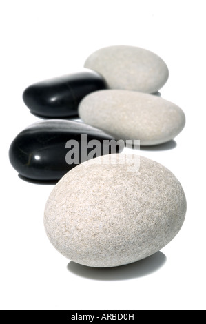 Black and White pebbles on a white surface high key shot with shadows Stock Photo