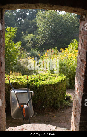 Wheelbarrow in charming Cotswold country garden, North Cerney near Cirencester, Gloucestershire, England Stock Photo