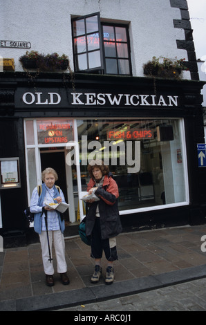 Two Women Eating Fish And Chips In Keswick Cumbria Stock Photo