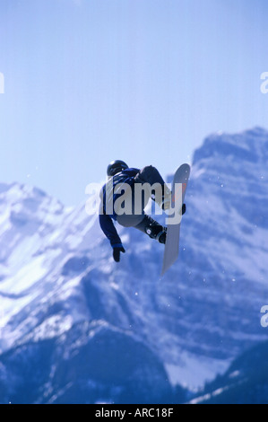 Snowboarder performing grab at big air competition in Canada Stock Photo