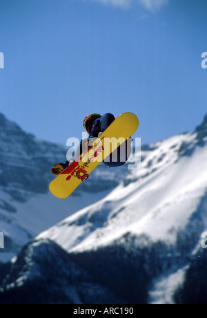 Snowboarder performing grab at big air competition in Canada Stock Photo
