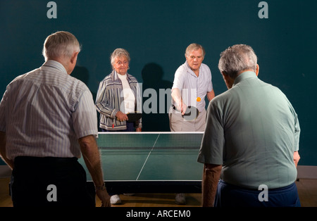 Senior men and women ranging in age from their 70 s to their 90 s play ping pong  MODEL RELEASE Stock Photo