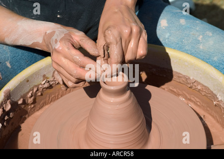 Young woman making a bowl on a potter's wheel Stock Photo