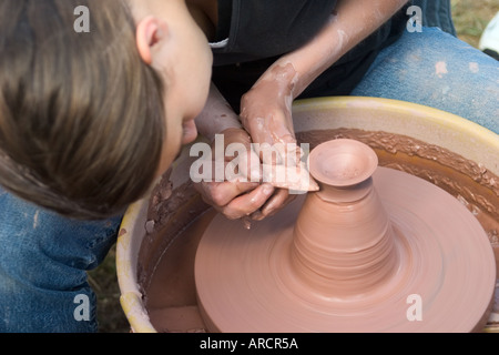 Young woman making a bowl on a potter's wheel Stock Photo