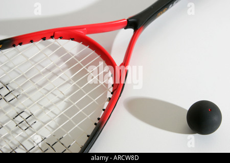 Red squash racket with black ball with red dot in studio Stock Photo