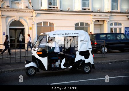 White & Black design on TucTuc/Tuk Tuk/Auto Rickshaw driving along Brighton promenade, UK Stock Photo