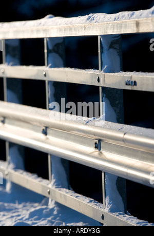 Closeup of a metallic snowy road bridge railing at Winter , Finland Stock Photo