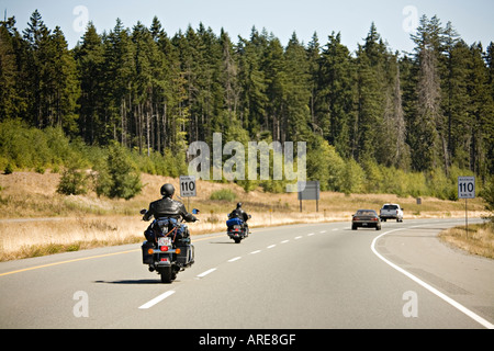 Motor cycles on road in forest area Vancouver island Canada Stock Photo
