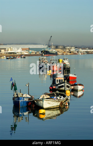 Fishing boats moored at Shoreham on the river Adur. Part of Shoreham port and cargo freighter in background Stock Photo