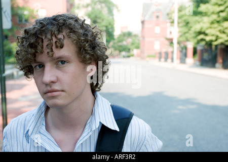 Young man standing outdoors with backpack Stock Photo