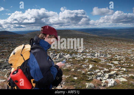 Middle aged female hiker checking her mobile phone Sanfjallet National Park Harjedalen Sweden August 2007 Stock Photo