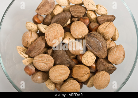 Various kinds of nuts in shells in the glass bowl from above overhead cut out cutout isolated on white table background nobody none hi-res Stock Photo