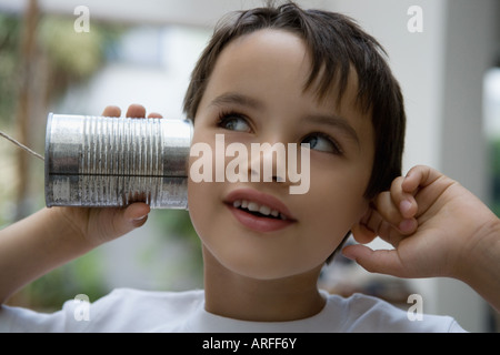 Boy using a tin can as a phone Stock Photo