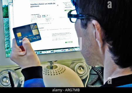 over shoulder, Young Asian Man Making Purchase online from Intenet "Web site" with Credit Card Shopping Stock Photo